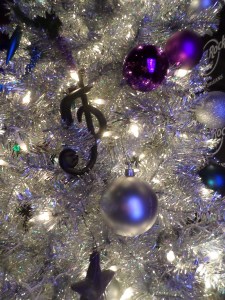 A close up of a silvery Christmas tree with purple ornaments