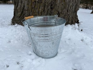 A photo of a steel bucket, sitting in snow
