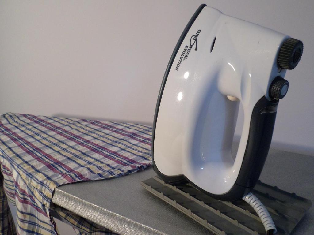 A shirt on an ironing board, ready for the steam iron.