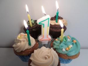 A plate of first anniversary cupcakes with candles