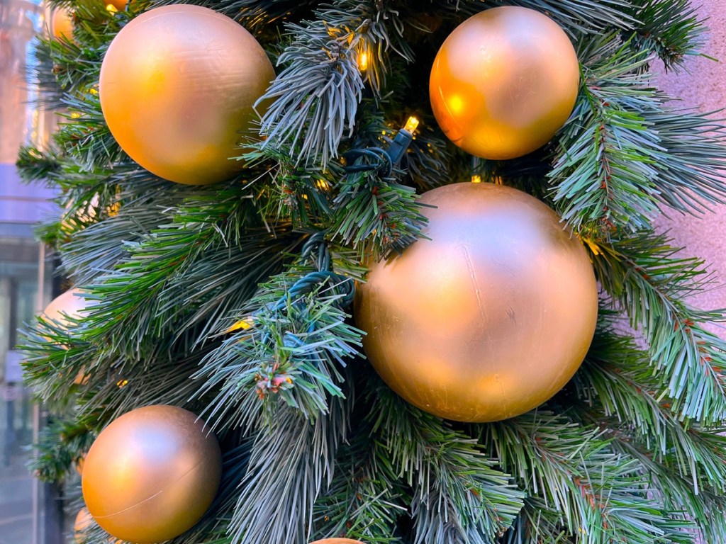 A close up of a Christmas tree and its golden ornaments.
