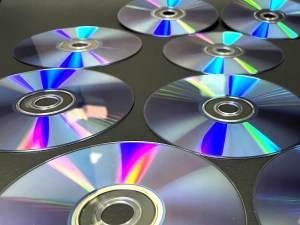 A close-up shot of some CDs with a light shimmering from above, creating a cool effect.