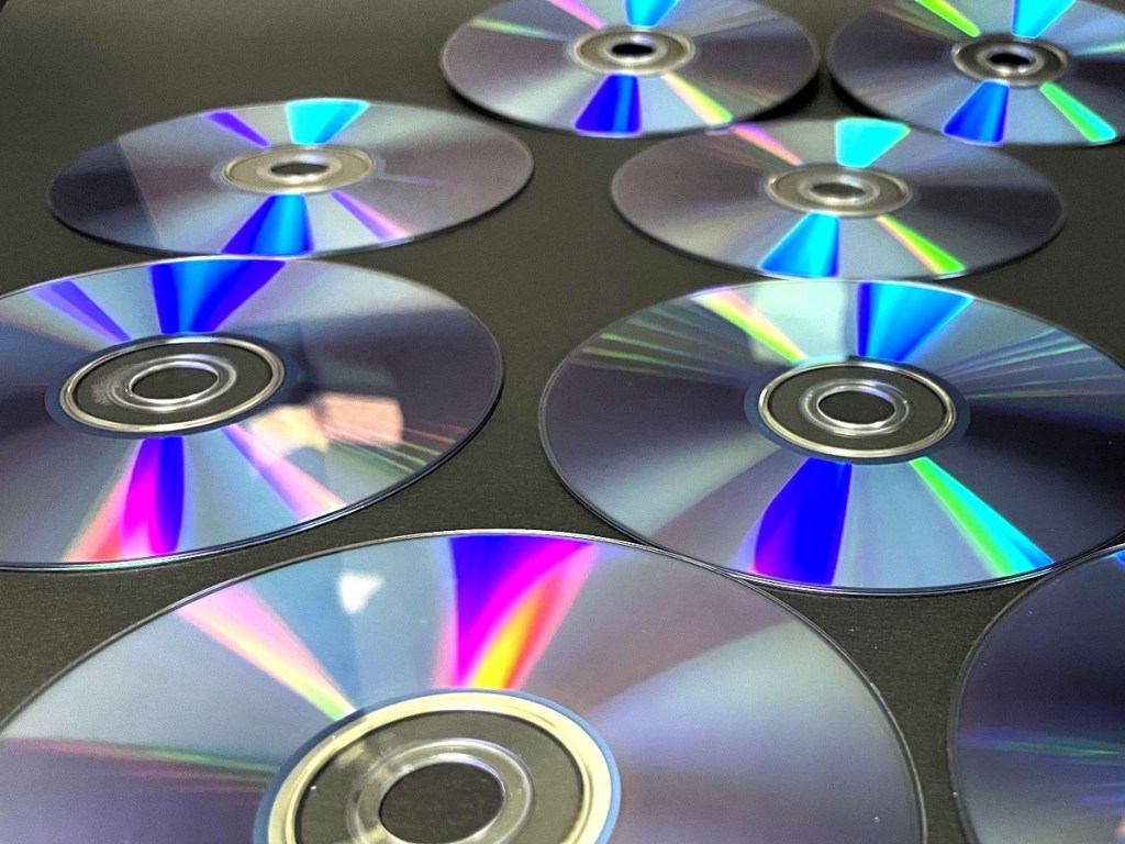 A close-up shot of some CDs with a light shimmering from above, creating a cool effect.