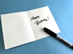 A blank card with a handwritten note saying "Happy Birthday"