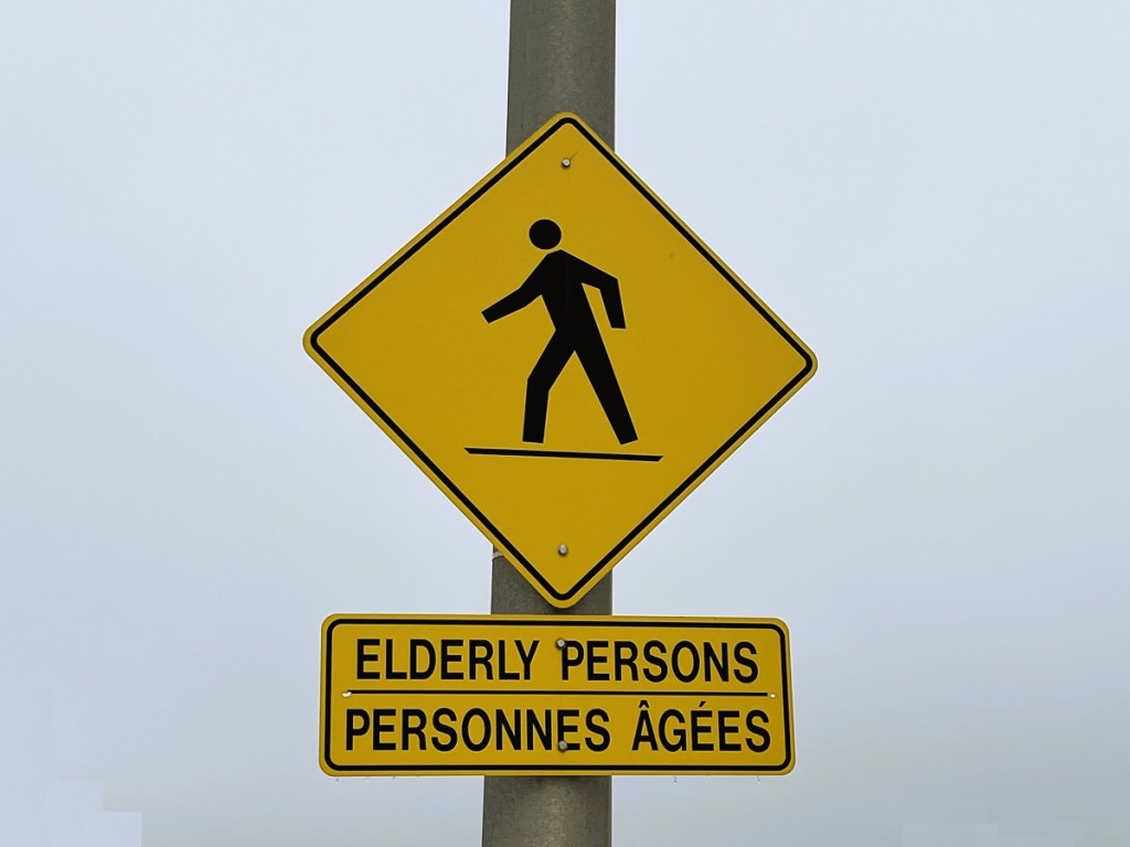 A sign indicating "elderly persons crossing" ahead.