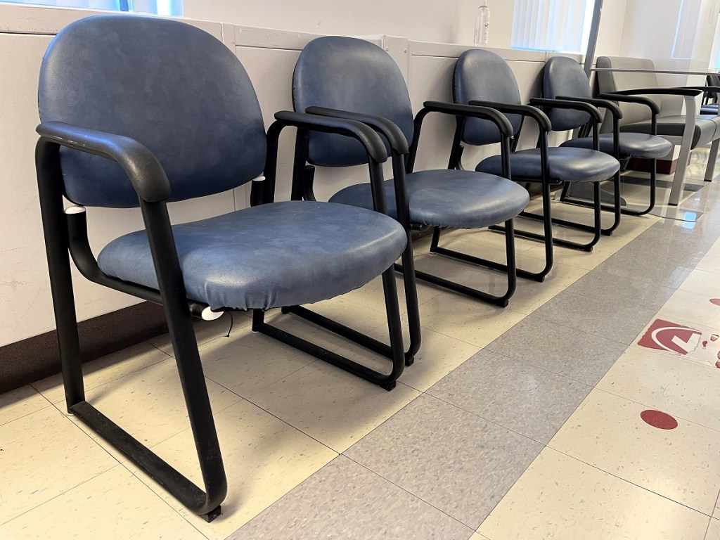 A row of blue chairs in a waiting room.