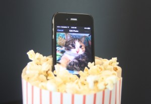 A bag of popcorn with a cell phone sitting in the middle