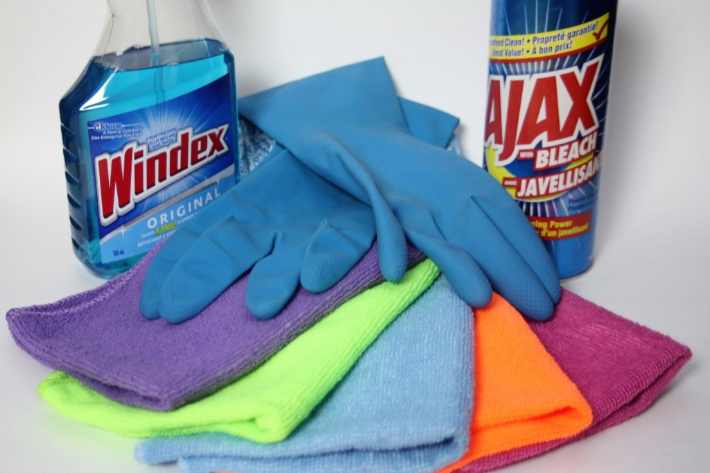 Cleaning products: a can of Ajax cleanser, a bottle of Windex, rubber gloves and microfibre cleaning cloths