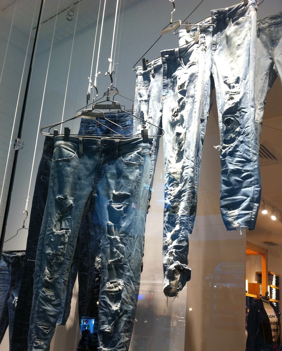 Distressed jeans hanging in a store window