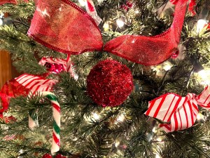 A close-up shot of cheerful red ornaments on a Christmas tree.