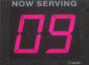 A sign saying "Now Serving, number 9"