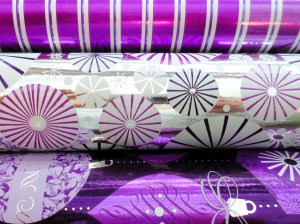 A close-up shot of three rolls of wrapping paper in cheerful colours.