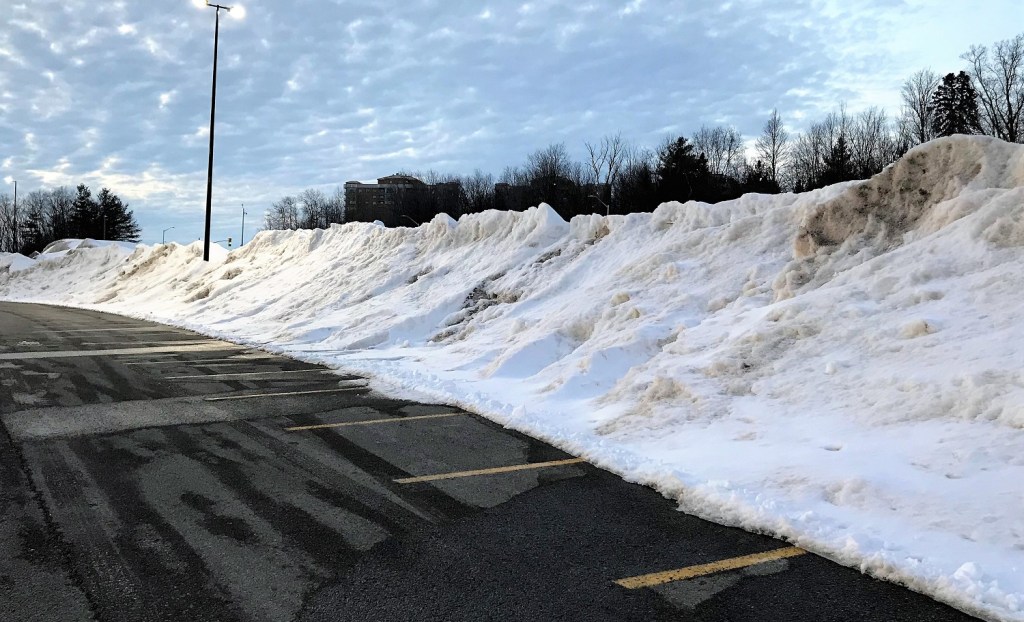 A large snow bank in a parking lot