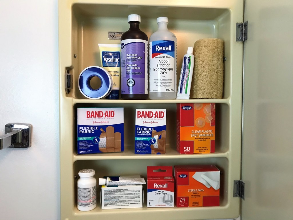 An open medicine cabinet containing an abundance of first aid products.