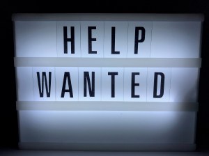 An illuminated sign indicating "help wanted"