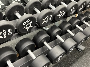 A close-up shot of a selection of dumbbell weights in a gym.