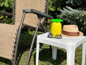 A lawn chair and a portable table on which we see a sun hat, a pair of sunglasses and a tropical drink. 