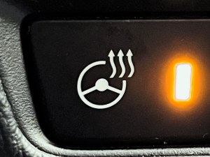 The icon representing the heated steering wheel functionality on a car.