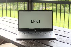 A notebook computer on a picnic table with the word "epic" appearing in large letters on the screen.