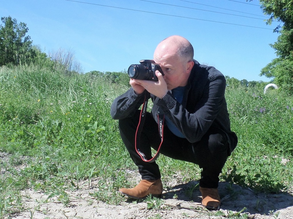 The author crouching in a field to take photo