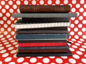 A stack of different styles of journals accumulated over the years.