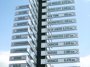 A sign post indicating the distance to major cities.