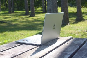 A notebook computer on a picnic table in a quiet park.