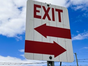 An exit sign that seems to indicate two passageways.